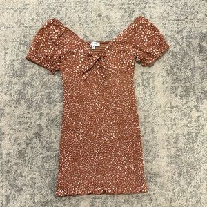 Burnt orange floral form-fitting dress with puff sleeves and a bow detail